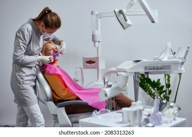 Young Woman Receiving Ultraviolet Light Procedure At Dentist Office