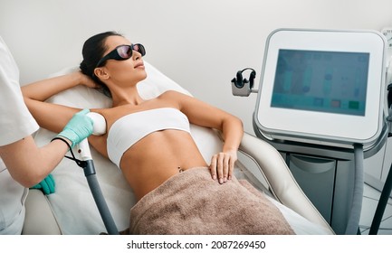 Young woman receiving underarm laser epilation and armpit hair removal using medical laser - Shutterstock ID 2087269450