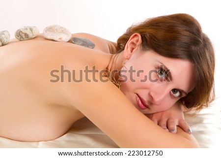 young woman receves stone therapy Beautiful young woman having a massage in a spa