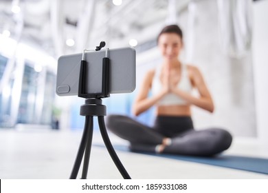 Young woman recording her vlog about yoga, while recording video on a smartphone. Sport couching and influencer concept - Powered by Shutterstock