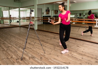 Young Woman Recording On Camera A Dance Lesson In A Choreography Hall With Mirrors. Woman Dancing Modern Dance.