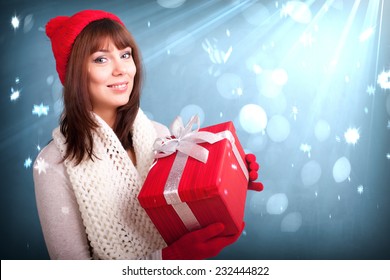 Young Woman In Red Cap Keeps Red Christmas Gif Box On Fantasy Background With Snowfall And Light