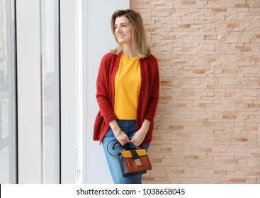 Young Woman In Red Cardigan Near Window Indoors