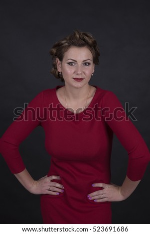 young woman in red dress with evening make-up on black background