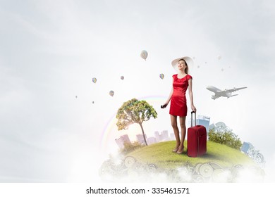 Young woman in red dress with red luggage with mobile phone in hand
