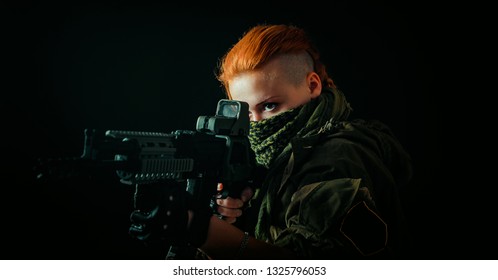 Young woman with red hair and girl with a bandage on his face, hold machinegun in military uniform.