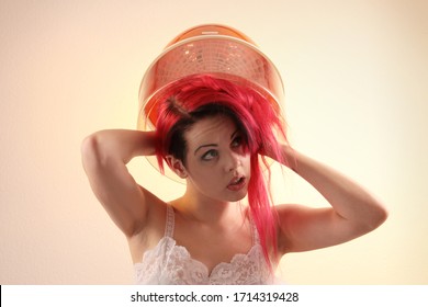 Young Woman With Red Hair Sitting Under A Hood Hair Dryer