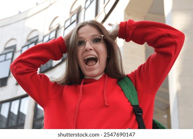 A young woman in a red hoodie shares her frustrations outdoors, capturing student life struggles candidly - Powered by Shutterstock