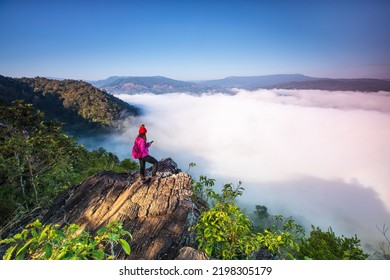 Young woman in red jacket hiking on Pha Muak mountain, border of Thailand and Laos, Loei province, Thailand. - Shutterstock ID 2198305179