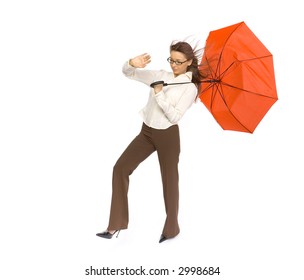 Young woman with red umbrella in hand fighting with strong wind blowing on her. Isolated on white in studio. - Powered by Shutterstock