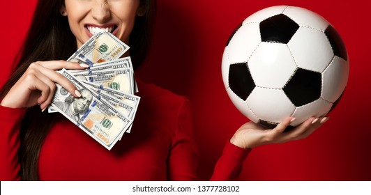 Young woman in red uniform hold soccer ball and dollar money for sports betting celebrating happy up with free text copy space on red background - Powered by Shutterstock