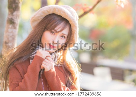 
A young woman reflected in the background of autumn leaves