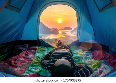 Young woman relaxed her feet to the outside of the tent.Camping and relax.Samednangchee viewpoint from phangnga thailand.