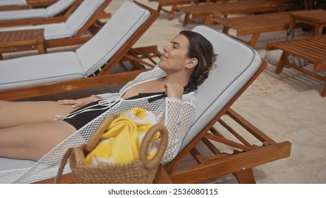 A young woman relaxes on a sunlounger at a luxurious bali resort, embodying travel and tranquility amid tropical charm. - Powered by Shutterstock