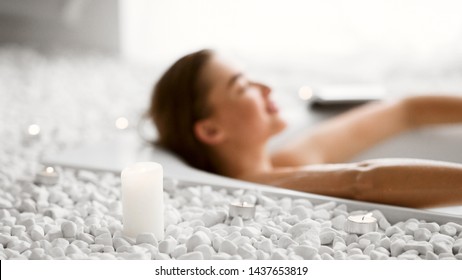 Young Woman Relaxing In Bath With Candles, Resting After Hard Day