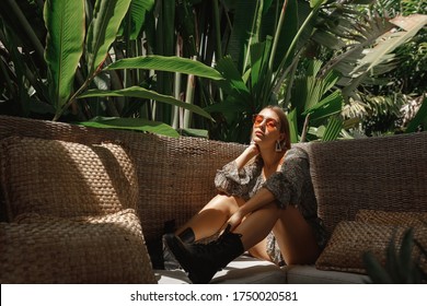 Young Woman Relaxing At The Beautiful Terrace While Sitting On The Chair.  Luxury Hotel Home Living Woman Relax Enjoying Sofa Furniture Of Outdoor Patio