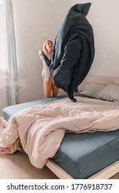 Young Woman Is Relaxing In Bed. Day Off. Bedtime. Early Morning Light. White, Beige, Grey. Light And Bright. Morning Ritual. Apartment Lifestyle Living. Cozy Bed Linen. Soft Pillow And Comforter.Focus