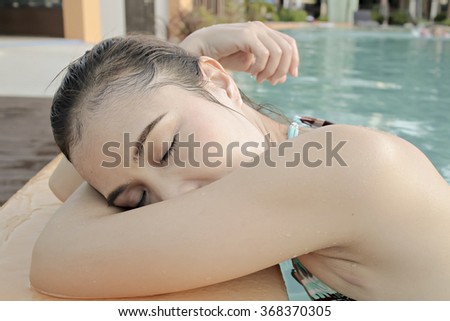 Young woman relaxing by pool in the evening.