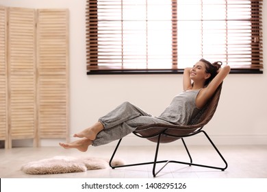 Young woman relaxing in chair near window with blinds at home. Space for text - Powered by Shutterstock