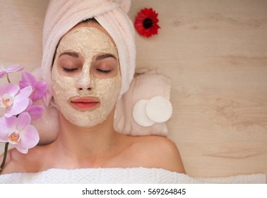 Young Woman Relaxing With Cosmetic Mask On Face At Beauty Salon- Indoors