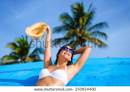 Young woman relaxing and enjoying at beach during tropical caribbean vacation travel. Beautiful girl in white bikini in Cancun, Mexico.