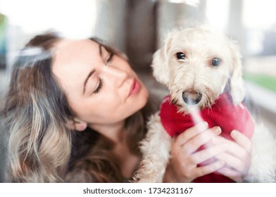 Young woman relaxing indoors at home with pet dog. Shot through glass.
