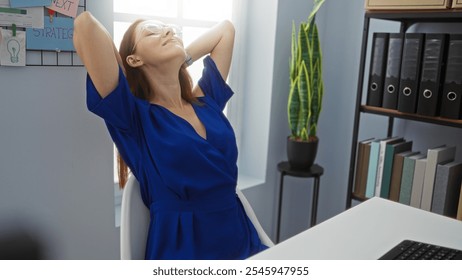 Young woman relaxing in modern office with indoor plant and paperwork in the background, surrounded by bookshelves and office supplies - Powered by Shutterstock