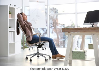 Young woman relaxing in office chair at workplace - Powered by Shutterstock