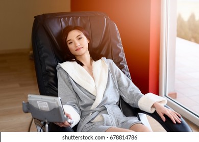 Young Woman Relaxing On The Massaging Chair At Home