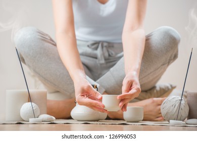 Young woman relaxing with tea and aromatherapy - Powered by Shutterstock