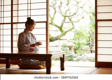 A Young Woman Is Relaxing At A Traditional Japanese Inn