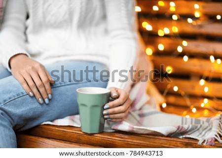 Young woman relaxing while drinking tea at home on winter day