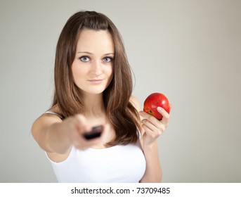Young woman with remote control and apple