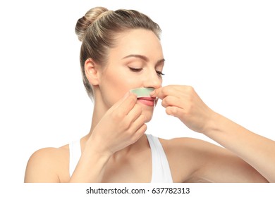 Young Woman Removing Hair From Face With Wax Strip