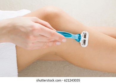 Young Woman Removing Hair On Legs With Razor. Body Care And Shaving Every Day. Smooth Skin.