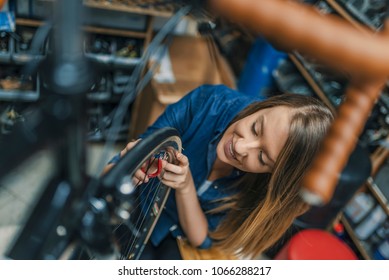 Young Woman Repairing Bicycle. Woman Working At Workshop. Small Business Owner. Bike Maintenance. Repair Technician Bicycles Was Repaired Gear Bike Shop.