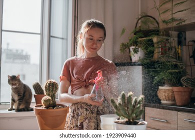 A Young Woman Replants And Water Cacti At Home. Beautiful Girl At Work With House Plants In The Apartment. Spring Potted Flower Care