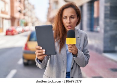 Young Woman Reporter Working Using Microphone And Touchpad At Street