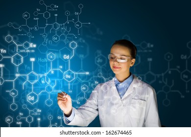 Young woman researcher in medical uniform drawing chemistry formulas - Powered by Shutterstock