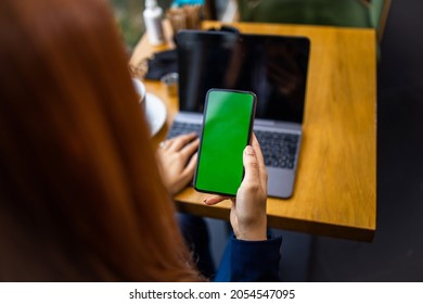 Young Woman In Restaurant Using Smartphone And Lap Top For Comunication.Green Screen.