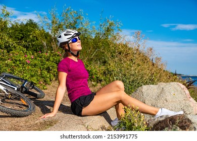  Young woman resting after riding bicycle at seaside 