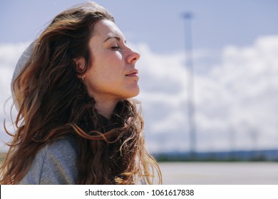 Young woman resting after run wearing a sweatshirt and breathing deeply - Shutterstock ID 1061617838