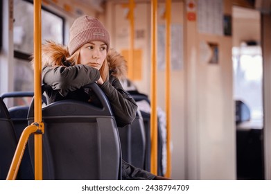 Young Woman Resting Chin on Hand in City Bus - Powered by Shutterstock