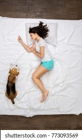 Young Woman Resting On The Bed Top View With A Dog Dreaming