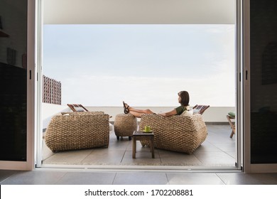 Young woman resting on terrace at home. Beautiful girl enjoying life. Vacations, relaxation, lockdown,resting, lifestyle and summer fun concept