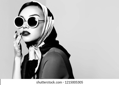 Young Woman In Retro Style. Sunglasses And Silk Scarf. Sixties Style Fashion Retro Woman. Black And White Image