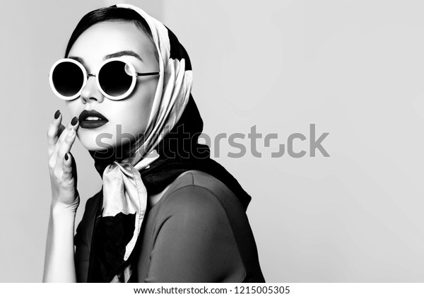 Young woman in\
retro style. Sunglasses and silk scarf. Sixties style fashion retro\
woman. Black and white\
image