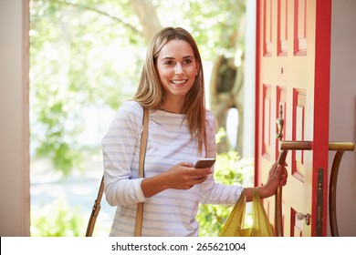 Young Woman Returning Home For Work With Shopping