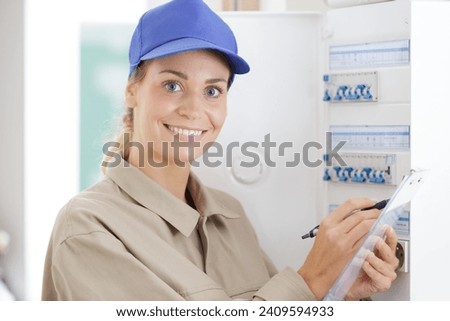 young woman rewrites the electrical meter readings