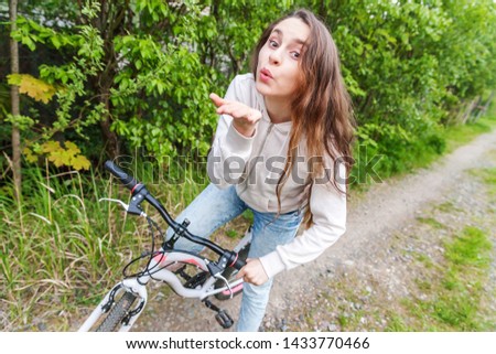 Young woman riding bicycle in summer city park outdoors. Active people. Hipster girl relax and rider bike. Cycling to work at summer day. Bicycle and ecology lifestyle concept